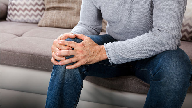 拿着疼痛膝盖的人手