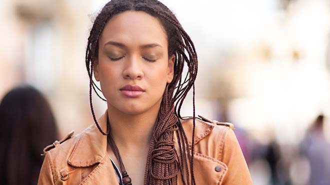 闭上双眼站在城市的人行道上